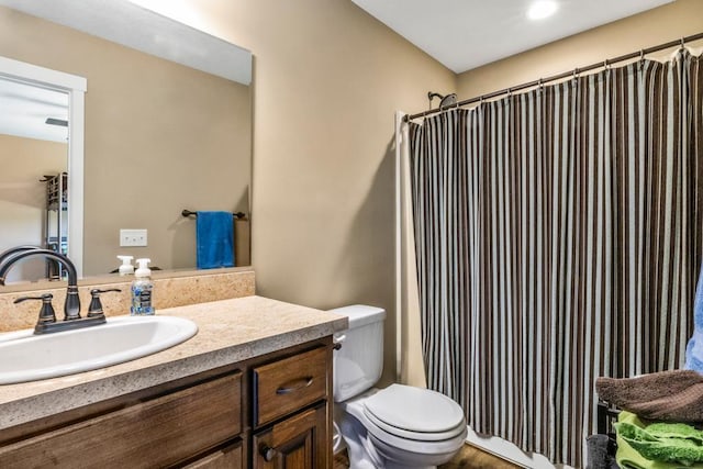 full bath featuring toilet, vanity, and curtained shower