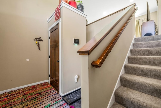 staircase with carpet floors and baseboards