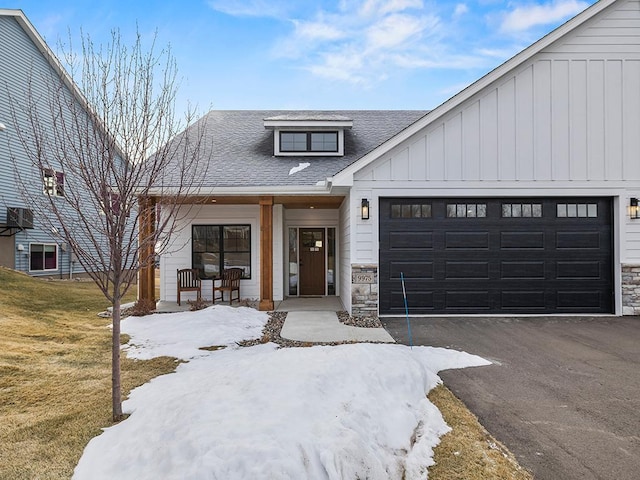 modern farmhouse featuring a lawn, a garage, and covered porch