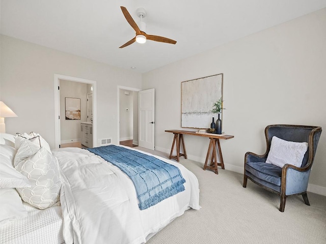 bedroom with light carpet, ensuite bathroom, and ceiling fan