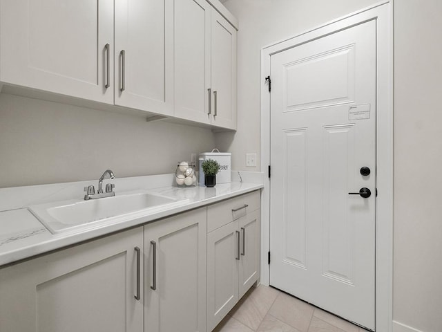 clothes washing area featuring sink and light tile patterned floors