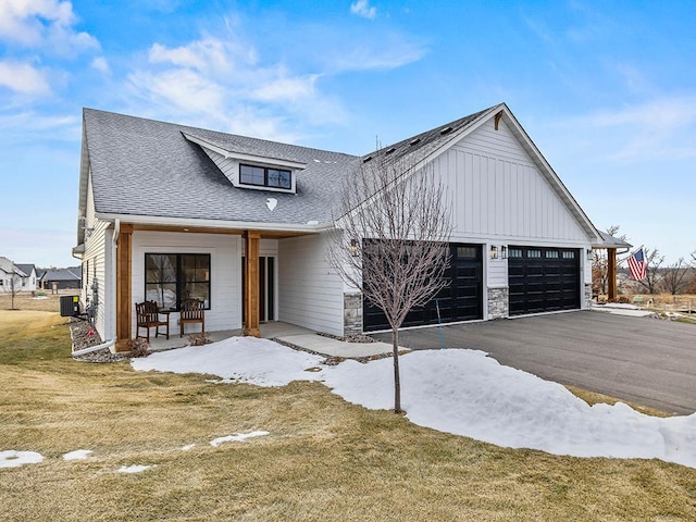 modern farmhouse with central AC, a garage, covered porch, and a front lawn