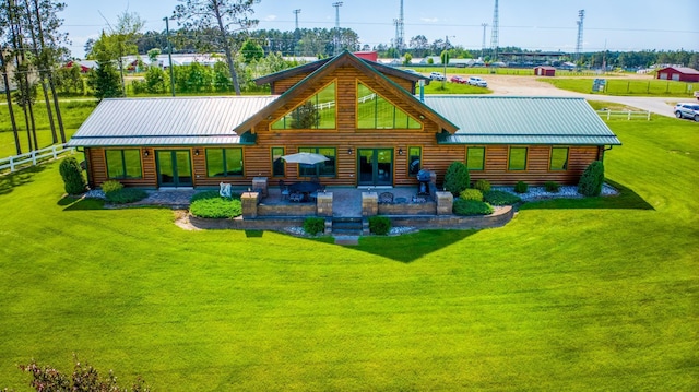 rear view of property with a patio and a lawn