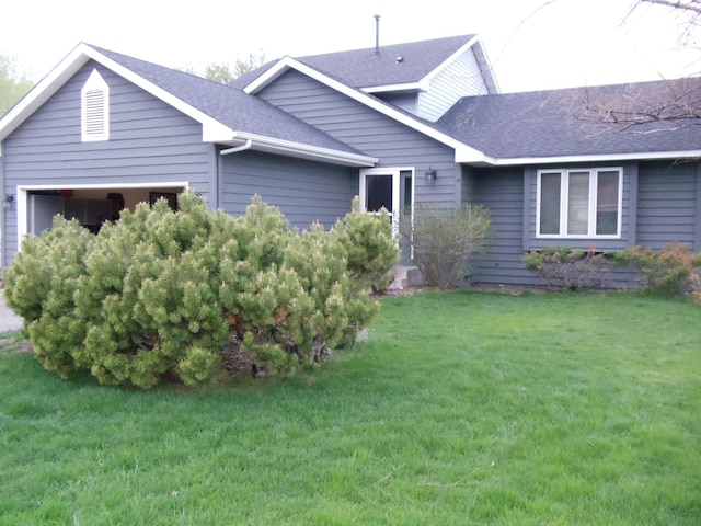 view of front of house with a garage and a front lawn