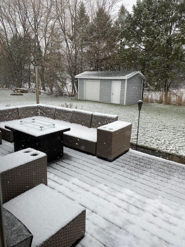 snow covered deck with a storage shed