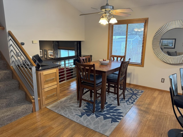 dining area featuring ceiling fan, a healthy amount of sunlight, lofted ceiling, and hardwood / wood-style flooring