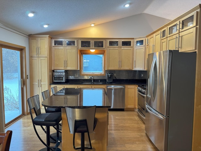 kitchen featuring a breakfast bar area, decorative backsplash, a center island, and appliances with stainless steel finishes