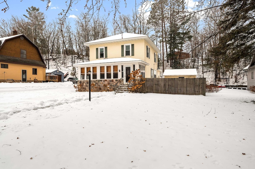 snow covered house with a sunroom