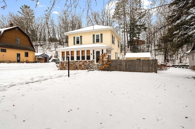 snow covered house with a sunroom