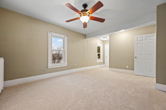 carpeted spare room featuring ceiling fan