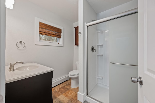 bathroom with vanity, toilet, a shower with shower door, and a baseboard radiator