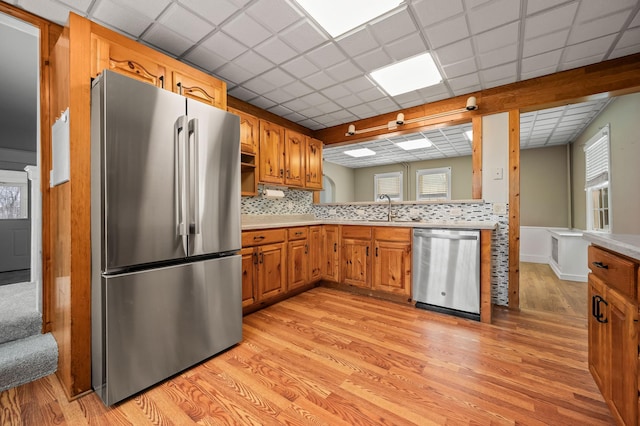 kitchen with a paneled ceiling, sink, backsplash, and appliances with stainless steel finishes