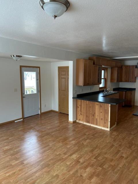 kitchen with kitchen peninsula, wood-type flooring, and a textured ceiling