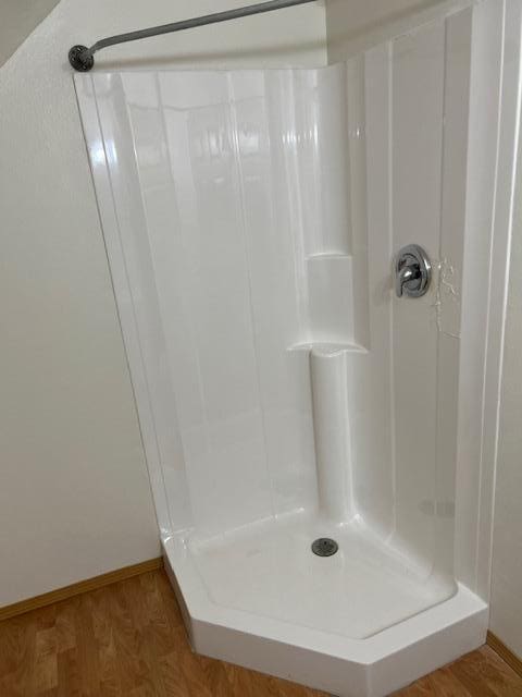 bathroom with hardwood / wood-style flooring and a shower