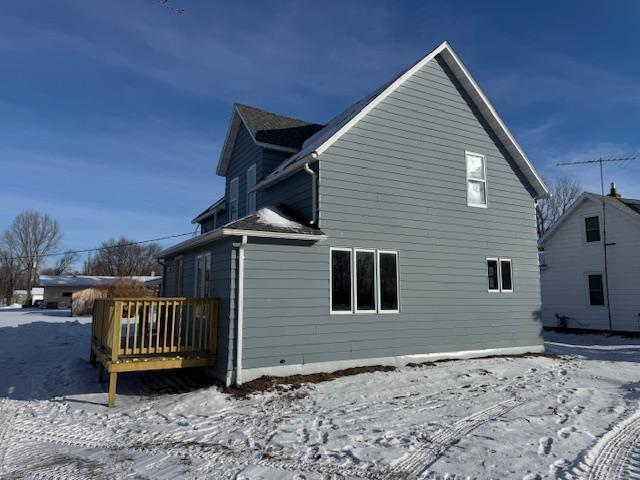 view of snowy exterior featuring a wooden deck