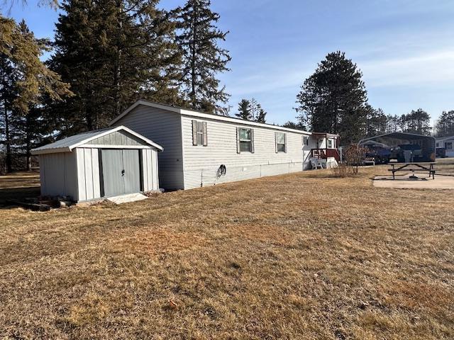 view of front of property with a storage unit and a front lawn