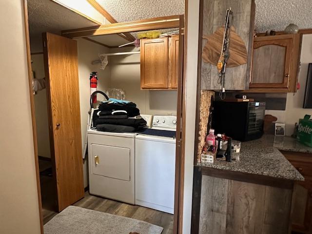 laundry room with light hardwood / wood-style floors, cabinets, and separate washer and dryer