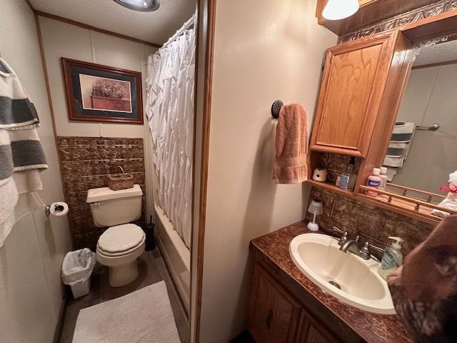 bathroom with backsplash, vanity, and toilet