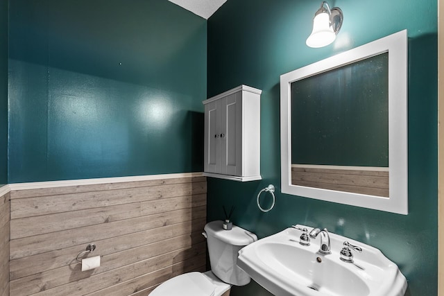 bathroom with a textured ceiling, toilet, and sink