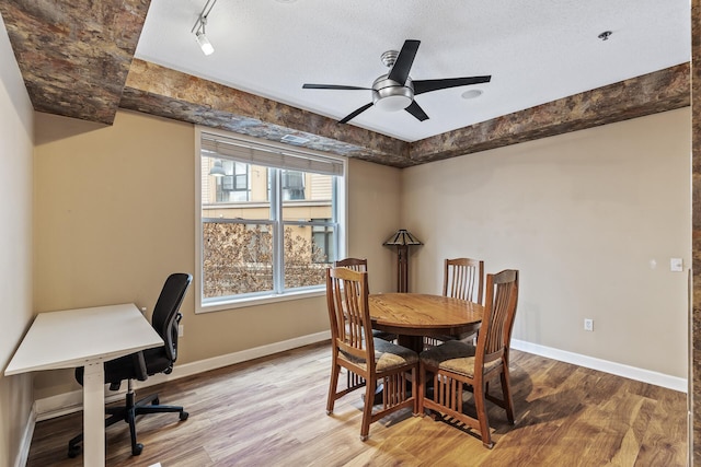 dining room with a textured ceiling, light hardwood / wood-style floors, ceiling fan, and rail lighting