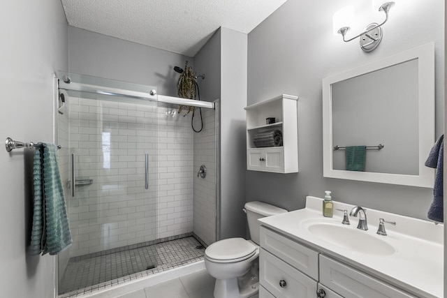 bathroom featuring vanity, tile patterned flooring, toilet, a textured ceiling, and an enclosed shower