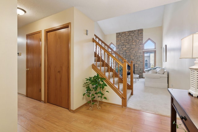 interior space with wood-type flooring, vaulted ceiling, and a textured ceiling