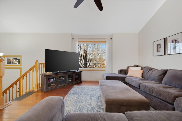 living room with hardwood / wood-style flooring, ceiling fan, and vaulted ceiling