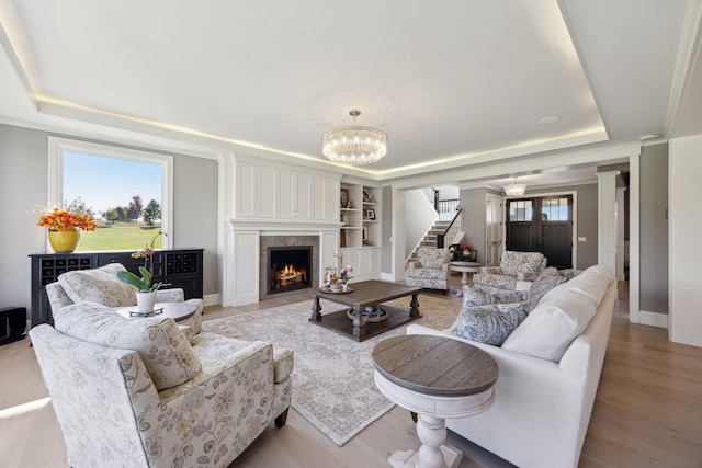 3175 Tuckborough Trl, Medina, MN 55356 - living room with a raised ceiling, stairs, a chandelier, and a fireplace