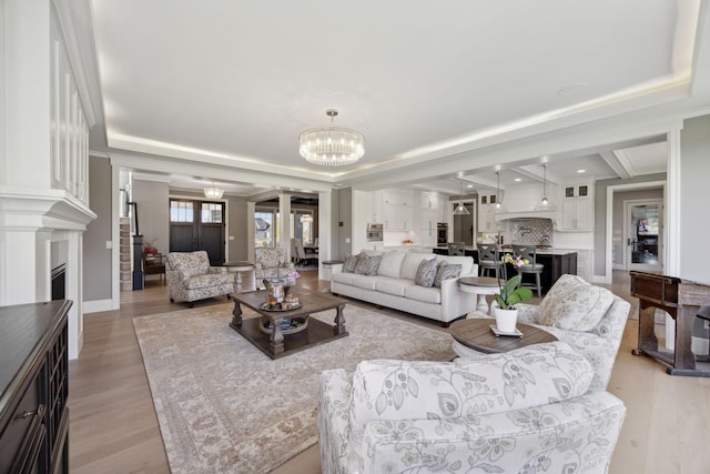 3175 Tuckborough Trl, Medina, MN 55356 - living area featuring a fireplace, a chandelier, and light wood-type flooring