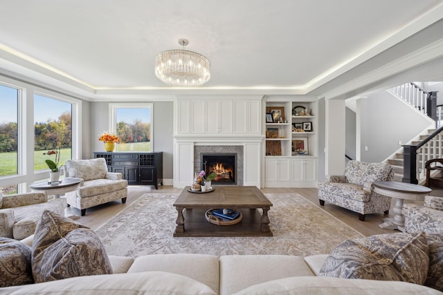 3175 Tuckborough Trl, Medina, MN 55356 - living room with a chandelier, stairs, light wood finished floors, and a tray ceiling