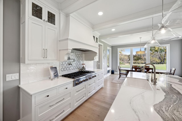 3175 Tuckborough Trl, Medina, MN 55356 - kitchen featuring stainless steel gas stovetop, ornamental molding, white cabinetry, backsplash, and decorative light fixtures