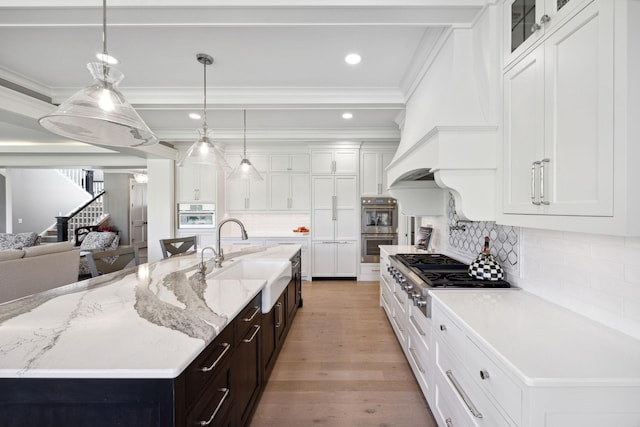 3175 Tuckborough Trl, Medina, MN 55356 - kitchen with appliances with stainless steel finishes, crown molding, white cabinets, light wood-style flooring, and backsplash