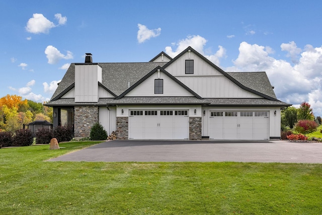 3175 Tuckborough Trl, Medina, MN 55356 - view of front facade featuring asphalt driveway, a front yard, a shingled roof, board and batten siding, and a chimney