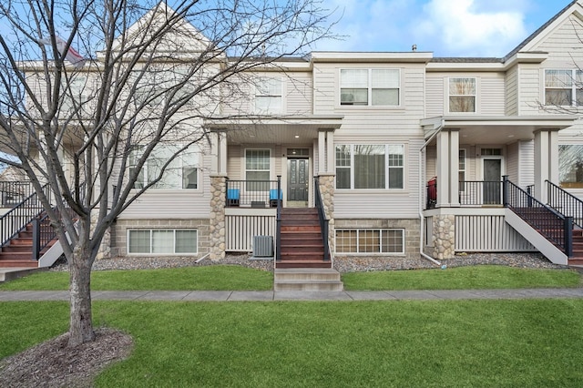 multi unit property featuring a front lawn and covered porch