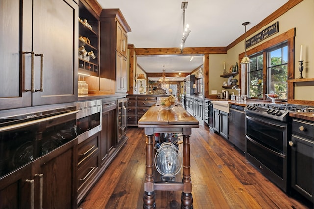 kitchen featuring dark wood-type flooring, hanging light fixtures, double oven range, dishwashing machine, and ornamental molding