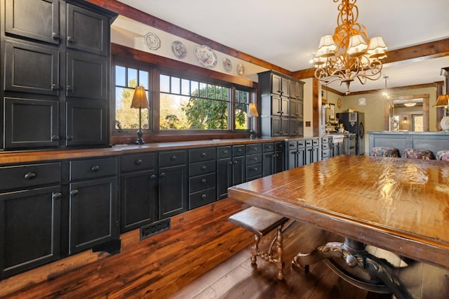 dining space with hardwood / wood-style floors and a chandelier