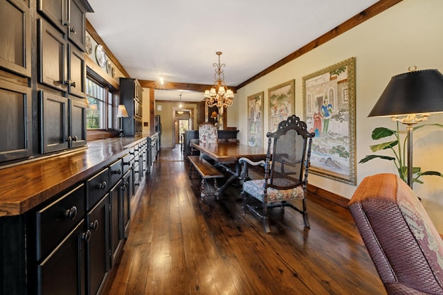 dining area with dark wood-type flooring, a chandelier, and ornamental molding