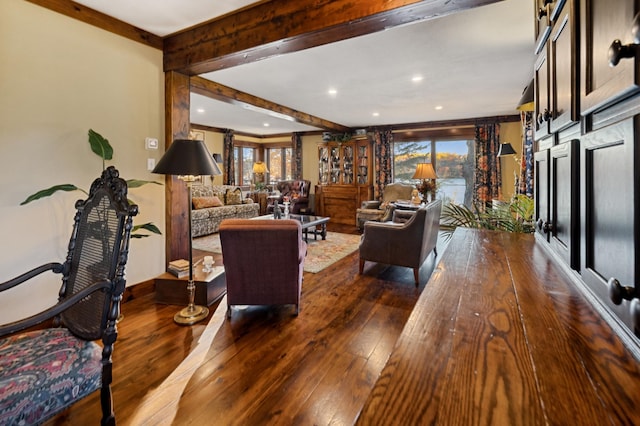 living room featuring beamed ceiling and hardwood / wood-style flooring