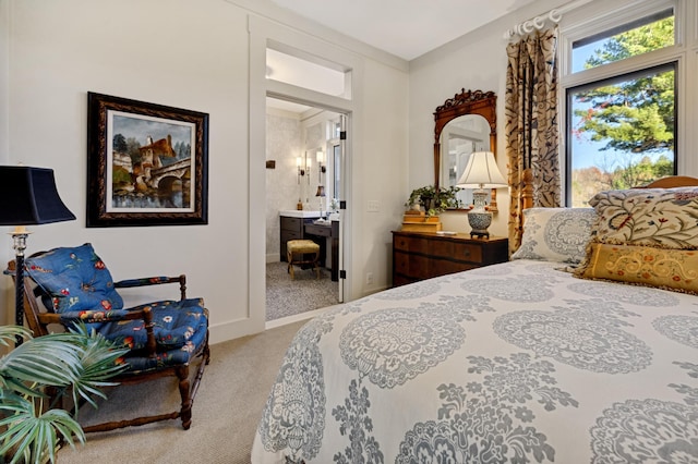 bedroom featuring ensuite bathroom and light colored carpet