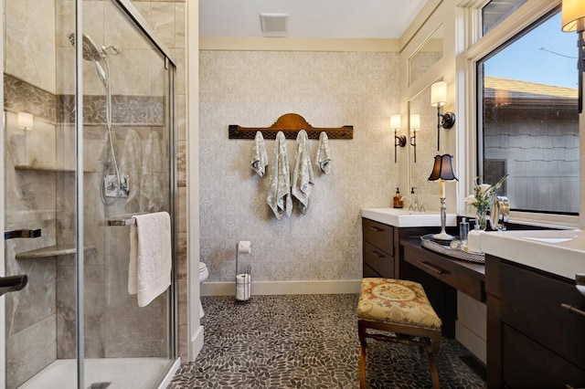 bathroom featuring tile patterned floors, vanity, toilet, and a shower with door