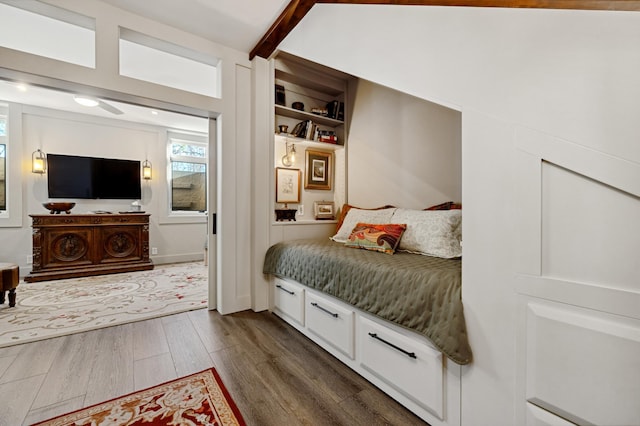 bedroom featuring beamed ceiling and dark wood-type flooring