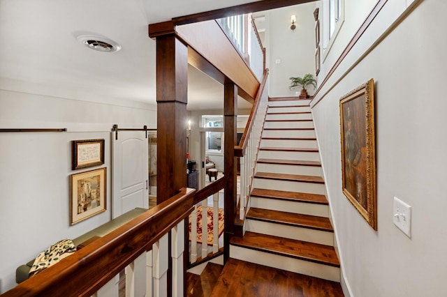 stairs featuring a barn door and wood-type flooring