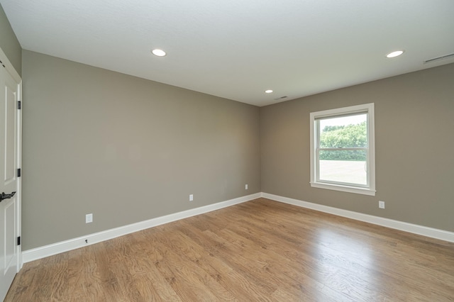 spare room with recessed lighting, light wood finished floors, and baseboards