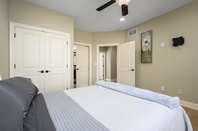 bedroom with visible vents, ceiling fan, baseboards, a closet, and wood finished floors