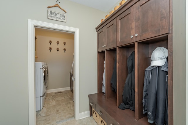 mudroom with baseboards and washing machine and clothes dryer