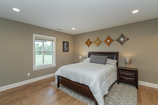 bedroom with recessed lighting, visible vents, wood finished floors, and baseboards