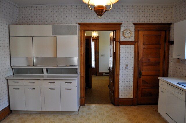410 5th St, Montevideo, MN 56265 - kitchen featuring wallpapered walls, white dishwasher, light countertops, white cabinets, and crown molding