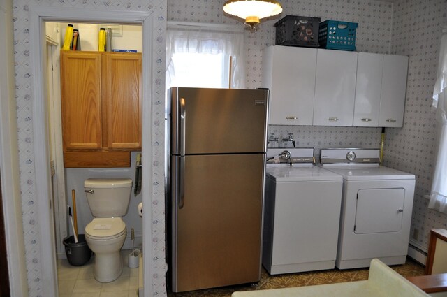 410 5th St, Montevideo, MN 56265 - washroom featuring independent washer and dryer, wallpapered walls, a baseboard radiator, cabinet space, and light tile patterned floors