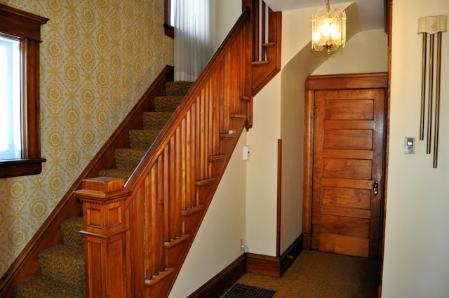 410 5th St, Montevideo, MN 56265 - stairs featuring wallpapered walls, a chandelier, and carpet