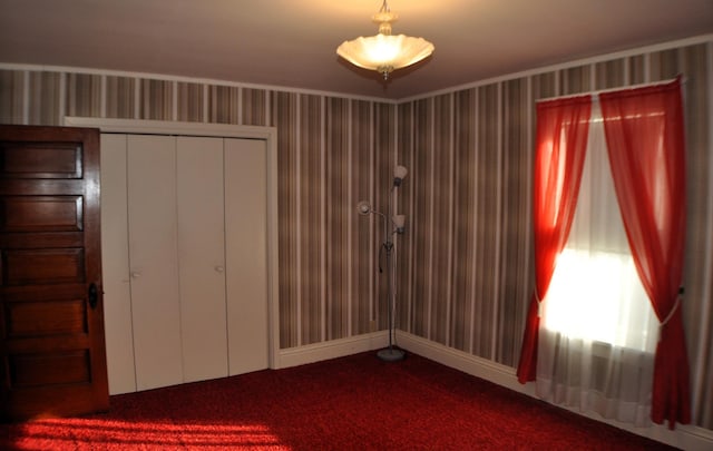 410 5th St, Montevideo, MN 56265 - unfurnished bedroom with dark colored carpet, a closet, and wallpapered walls